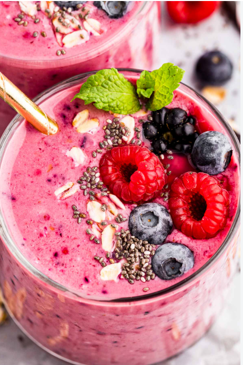 Berry smoothie topped with raspberries, blueberries, chia seeds and mint